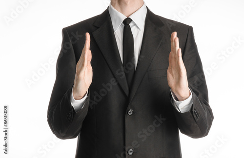 Businessman and gesture topic: a man in a black suit with a tie showing hands gesture on an isolated white background in studio