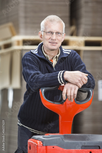 Confident Worker Leaning On Handtruck