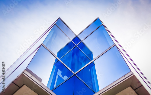 Perspective and underside angle view to textured background of modern glass blue building roof