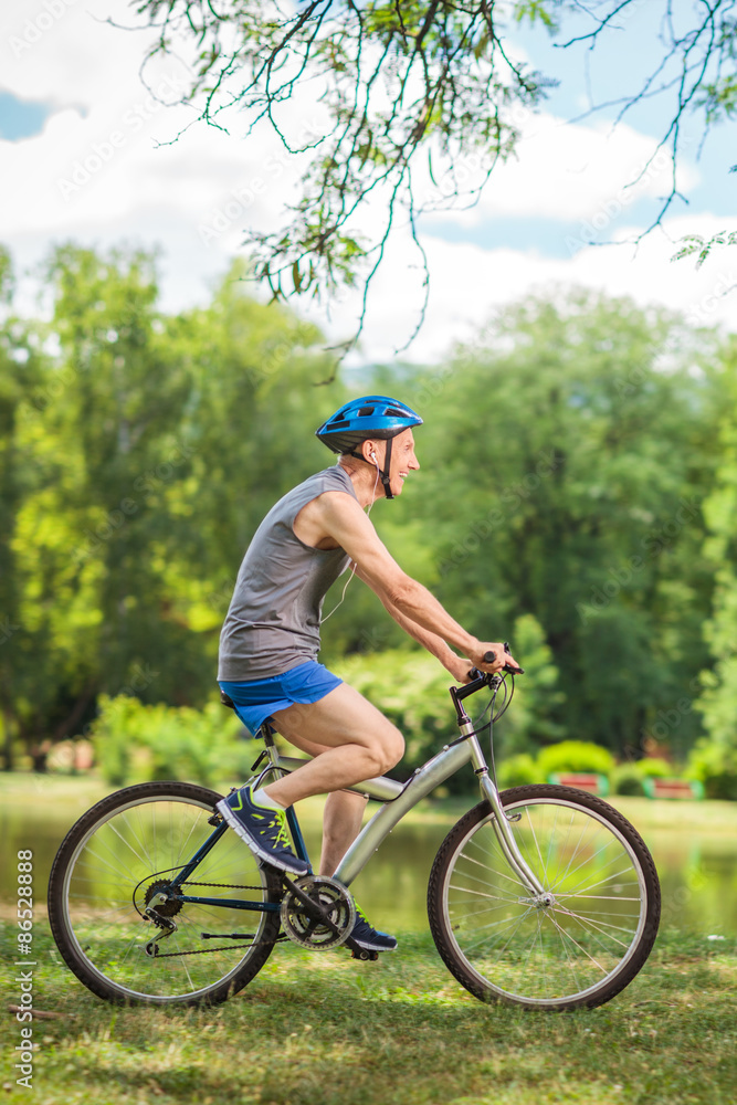 Active senior man riding a bicycle in a park Active senior man riding a bicycle in a park