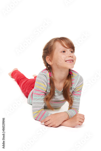 Front view of smiling child girl lying on floor