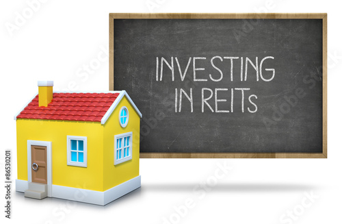 Investing in reits text on blackboard with 3d house