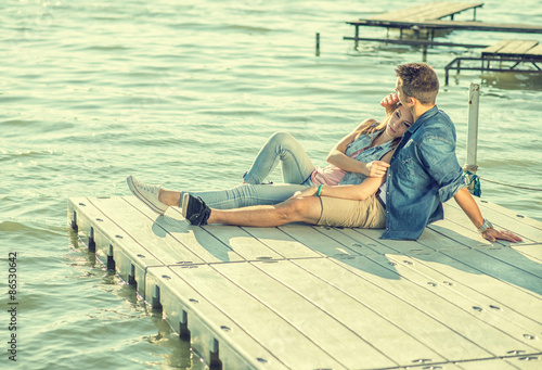 Couple in love sitting on the pier, embrace