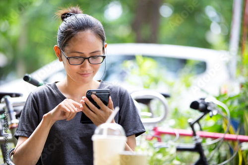 Young Asian woman  using smartphone in garden