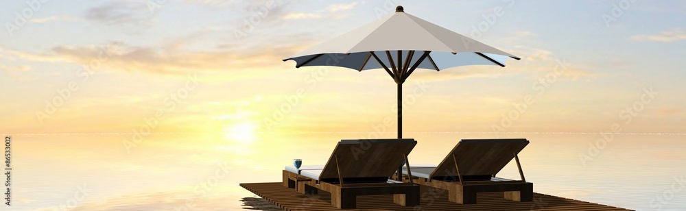 Deck Chairs and umbrella in sunset on the beach