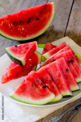 Fresh slices of watermelon on a plate on the wooden table