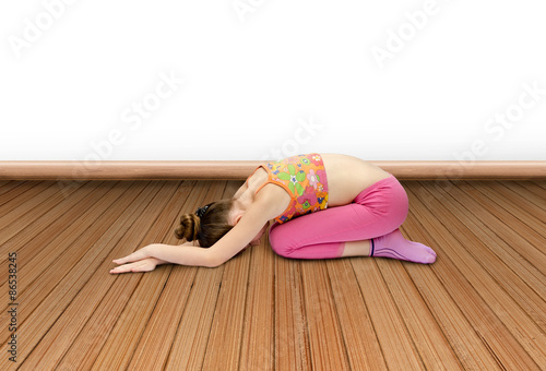  little girl practices yoga indoors