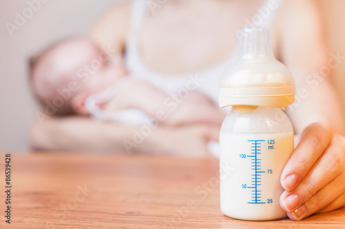 Mother holding a baby bottle with breast milk