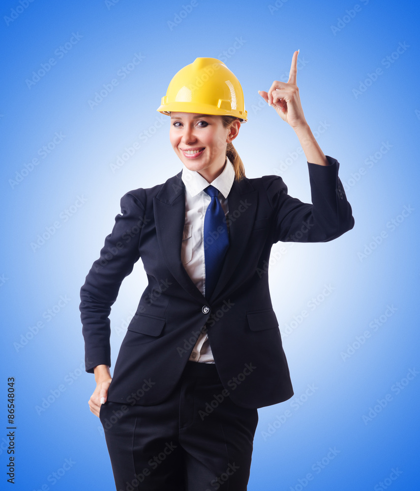 Young businesswoman with hard hat against gradient Young businesswoman with hard hat against gradient