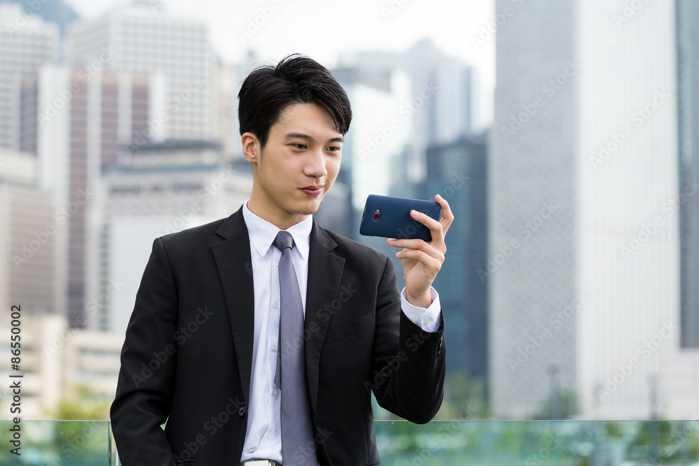 Businessman read on the cellphone at outdoor