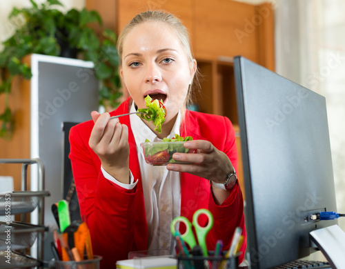 Businesswoman having lunch in office photo