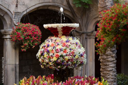Egg n jet of water in the fountains decorated with flowers photo