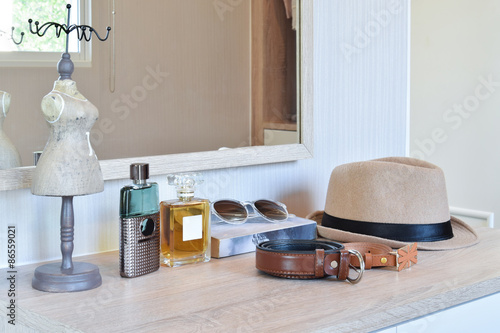 Vászonkép brown hat ,perfume and leather belt on a wooden dressing table