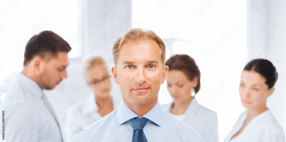 businessman in office with group on the back businessman in office with group on the back