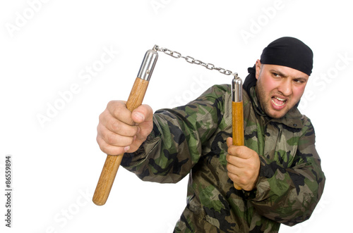 Young man in soldier uniform holding nunchaks isolated on white photo