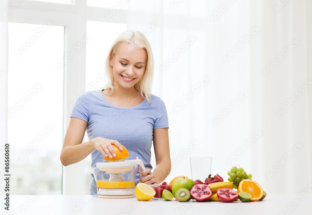 smiling woman squeezing fruit juice at home