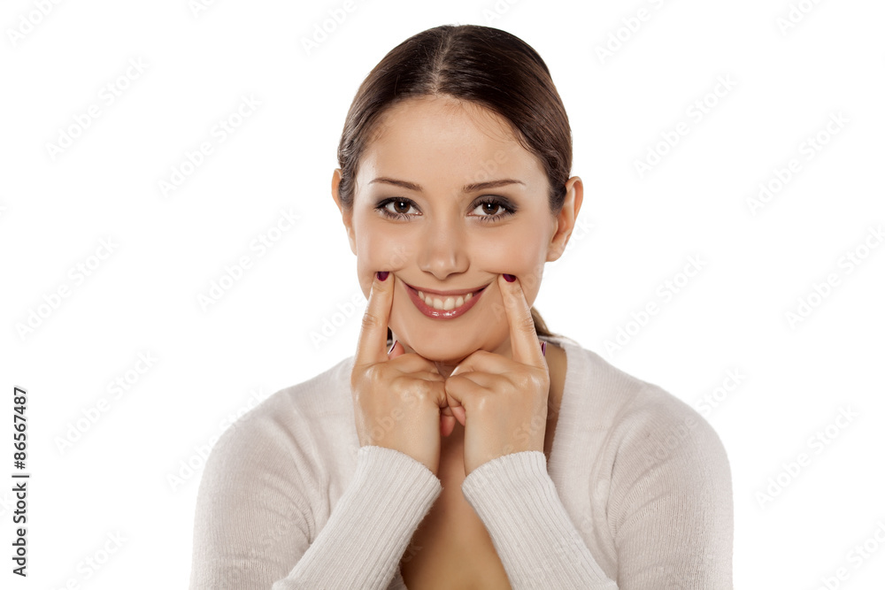 Beautiful young woman forced a smile with her fingers Beautiful young woman forced a smile with her fingers