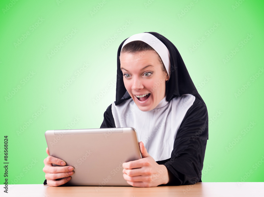 Nun working on laptop - religious concept Nun working on laptop - religious concept