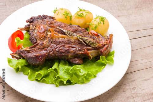 Roasted lamb ribs with rosemary and garlic on ceramic plate