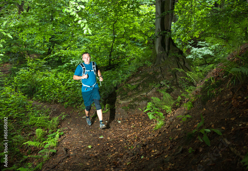 middle age trail runner training on the forest track