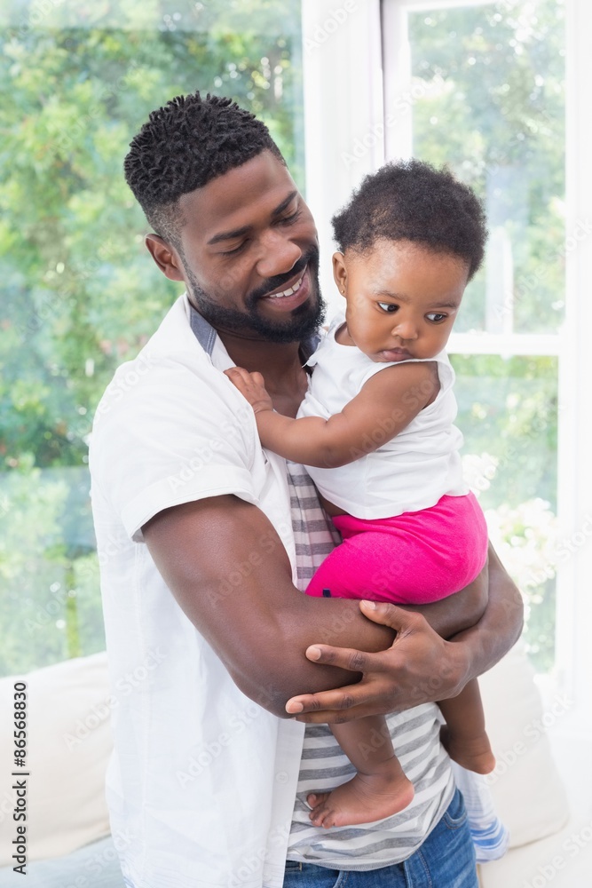 Obraz premium Happy father with baby girl on couch