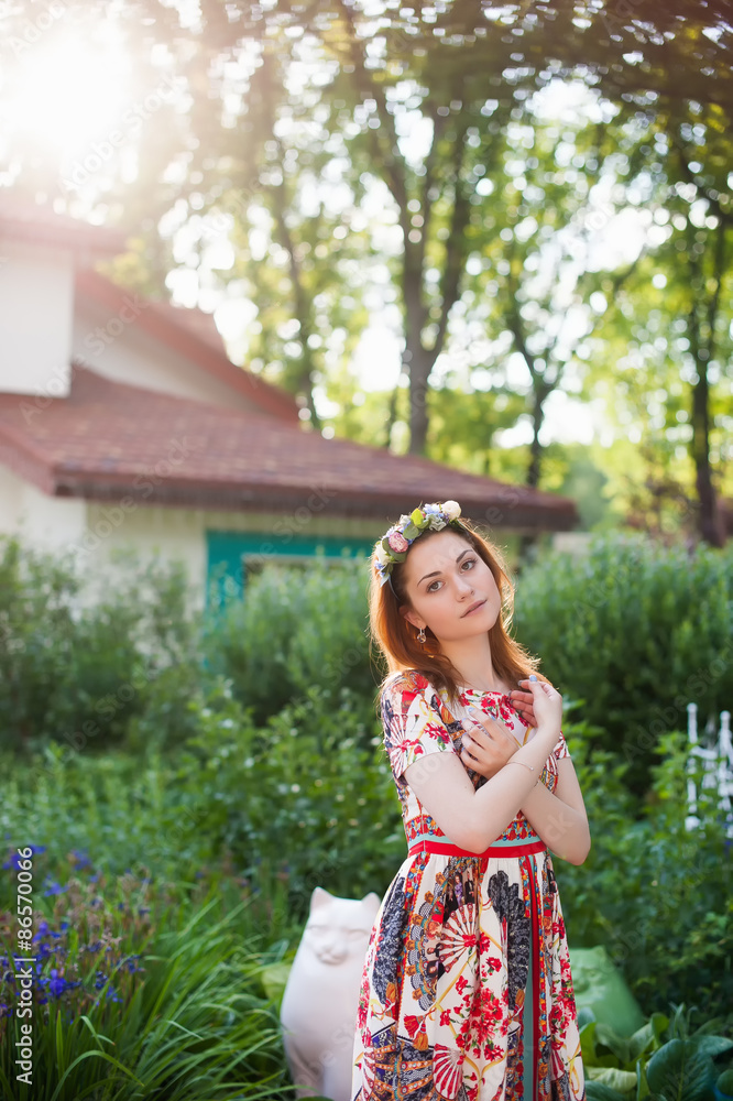 Portrait of a beautiful young woman in a bright dress on a head a wreath of flowers, lifestyle, youth