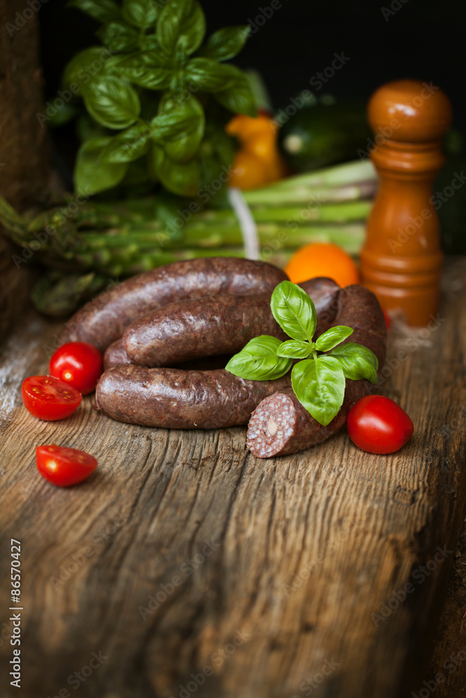 Black pudding, with cut slices, on chopping board over stone background. Krupniok really Polish black pudding.
