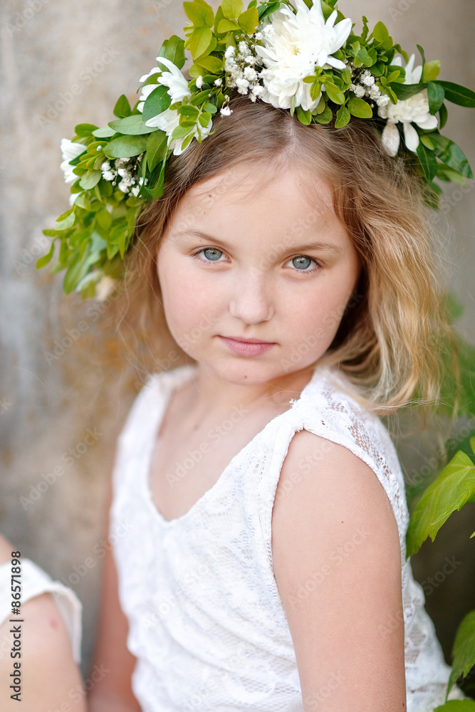Fototapeta premium portrait of a beautiful little girl with flowers