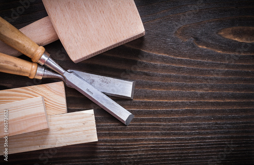 Lump hammer firmer chisels and wooden planks on brown hardwood c