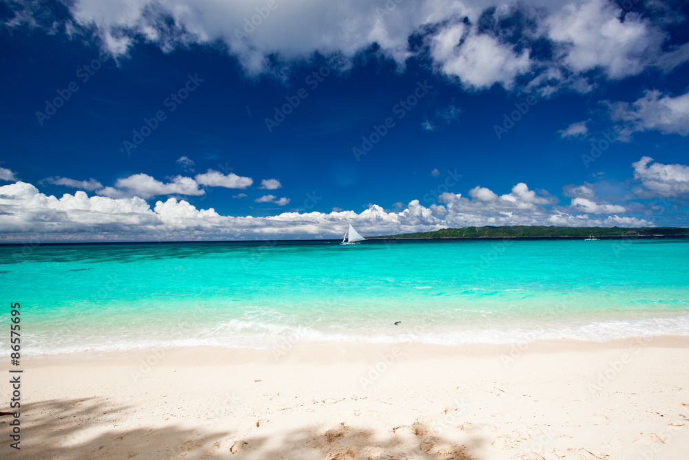 Fototapeta premium Beach with sailboat in ocean