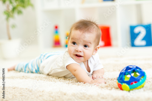 crawling funny baby boy on floor at home