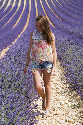 Fototapeta Naklejka Na Ścianę i Meble -  Young woman in floral field of lavender