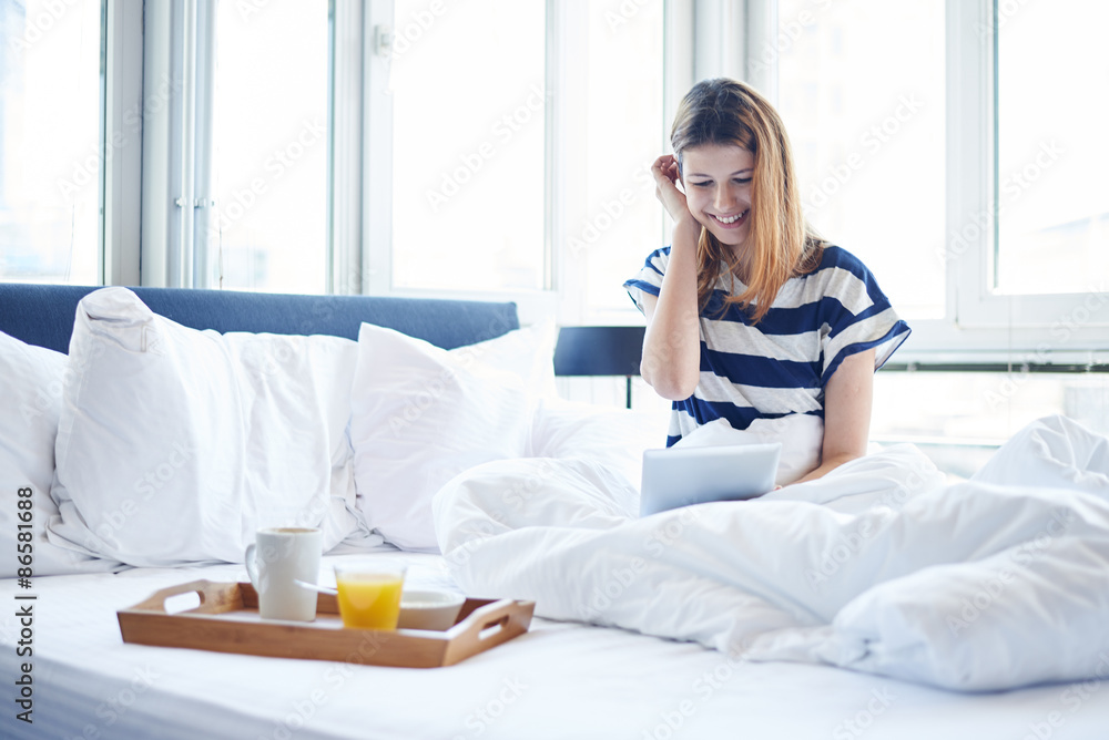 Young woman  reading digital tablet in bed