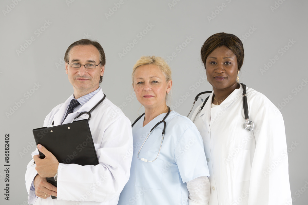 Threesome of self confident medical specialists smiling and looking at the camera Threesome of self confident medical specialists smiling and looking at the camera