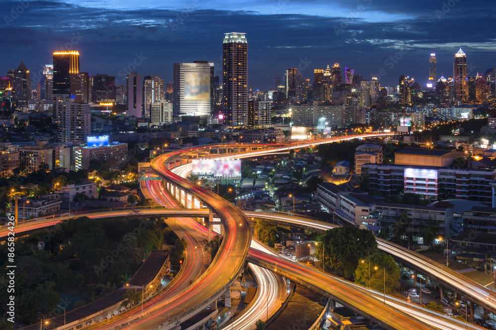 Fototapeta premium Bangkok nightscape / a scene of traffic trail lights on highways at night in the middle of Bangkok City, Thailand