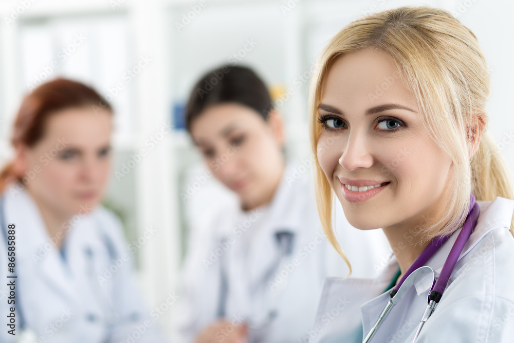Portrait of smiling female medicine doctor with two colleagues Portrait of smiling female medicine doctor with two colleagues