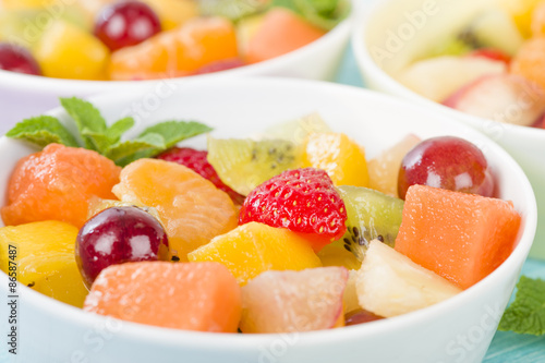 Fruit Salad - Bowls of fresh fruit salad on a blue background.