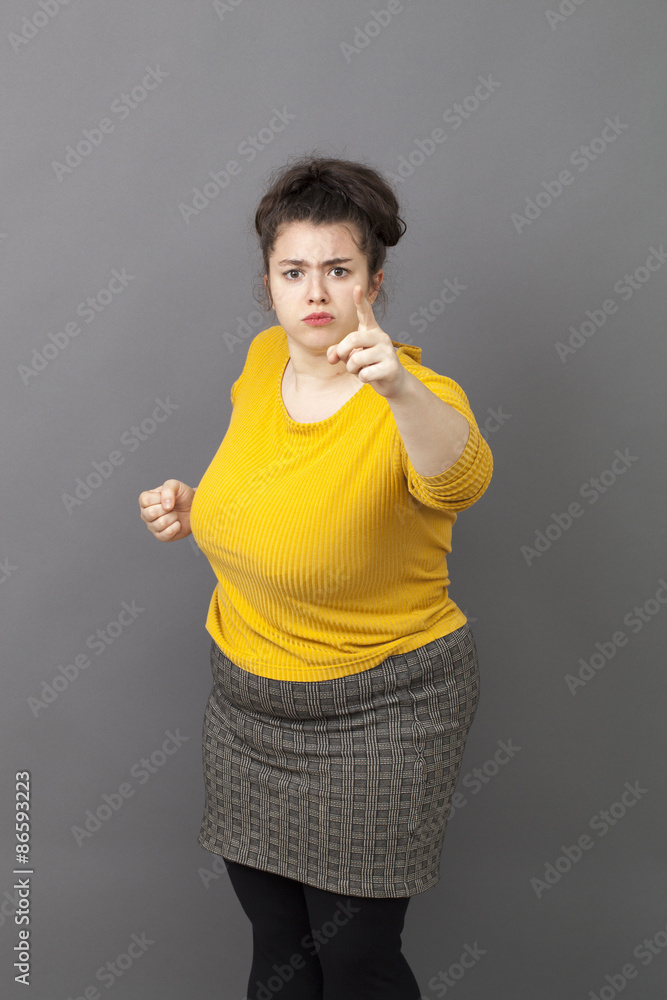 bullying oversize young woman staring at someone with finger pointing forward with blaming attitude and self-assurance bullying oversize young woman staring at someone with finger pointing forward with blaming attitude and self-assurance