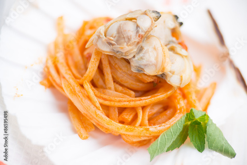 Spaghetti con vongole  e sugo al pomodoro conditi nella conchiglia photo