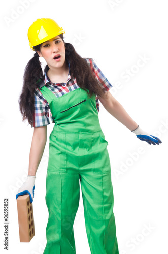 Female workman in green overalls holding brick isolated on white