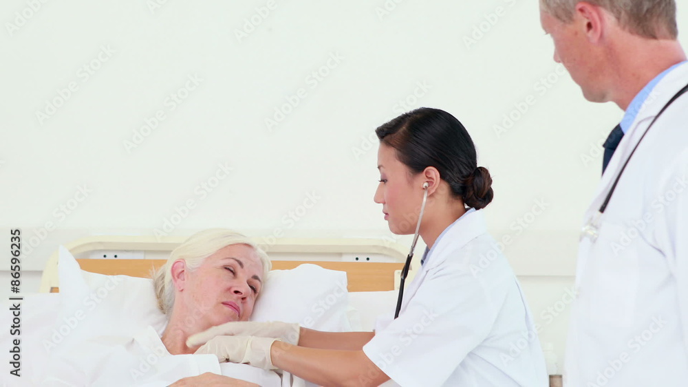 Serious doctor using her stethoscope Serious doctor using her stethoscope