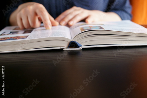 Ricercatrice mentre studia con le mani sul libro photo