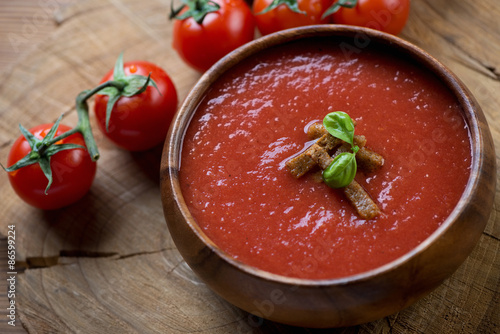 Wooden bowl with tomato soup gazpacho, studio shot, close-up