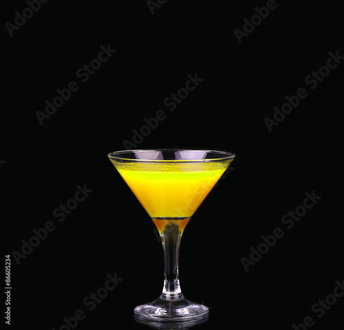 Yellow cocktail in martini glass isolated on black background