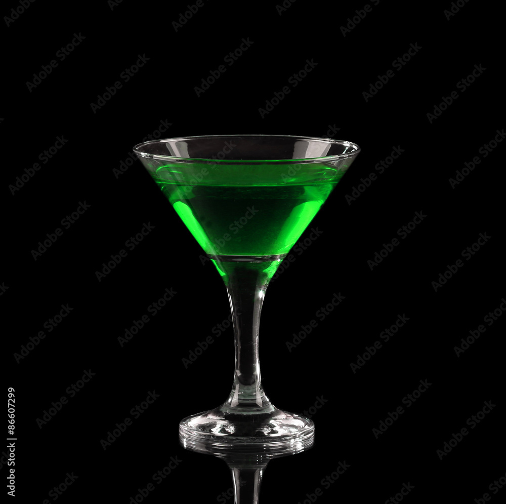 Green alcoholic cocktail in a glass on black Green alcoholic cocktail in a glass on black