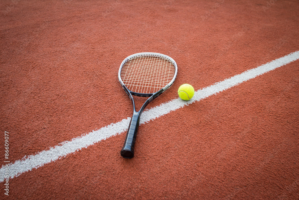 Tennis racket and ball on court