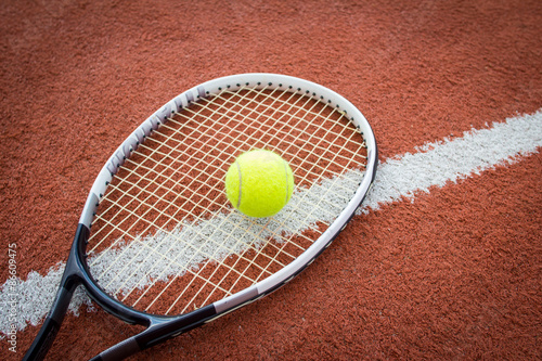 Tennis racket and ball on court © mrstam