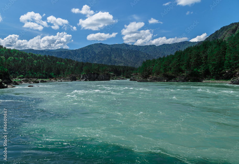 the merger of two mountain rivers in the background peaks