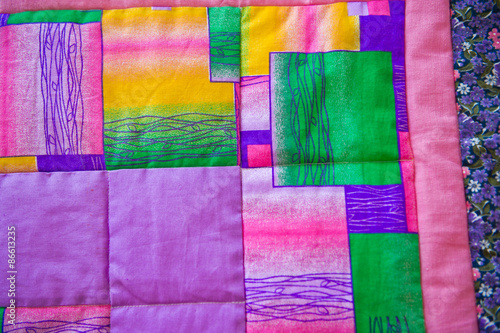 Blanket on a bed from bright pieces of a fabric 3024.