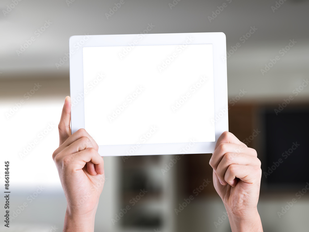 Man holding a tablet pc with blank screen in a house Man holding a tablet pc with blank screen in a house
